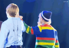a couple of men standing next to each other on a stage .