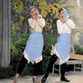 two women are standing next to each other and one has a scarf on her head