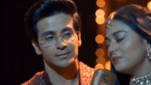 a man and a woman are singing into a microphone together .
