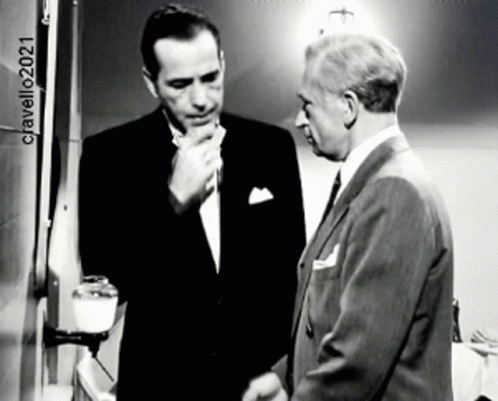 Black and white clip, Bogart in "In a Lonely Place," talks to another man, they leave the room. Subtitle: "Remind me to get you another tie.: