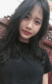 a woman in a black shirt is taking a selfie