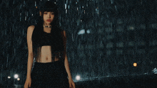 a woman stands in the rain in front of a sign that says love xxx