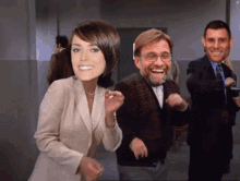 a woman in a suit is dancing with two men