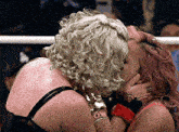 two women kissing in a ring with one wearing a bracelet that says " love "