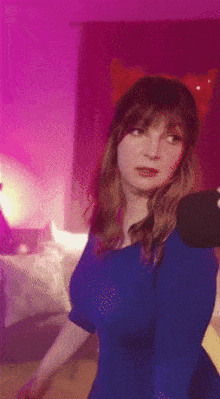 a woman in a blue dress takes a picture of herself
