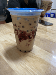 a person holding a cup that says ' iced coffee ' on it