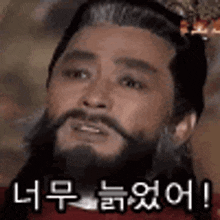 a man with a beard and a crown on his head is making a funny face in a foreign language .