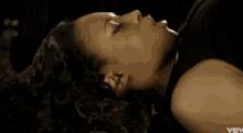 a close up of a woman 's face with curly hair making a funny face .