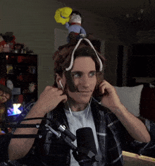 a man wearing a headband with a stuffed animal on top