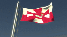 a red and white flag with a cross on it is flying in the wind