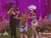 two women wearing masks are dancing in a room with the word party on the bottom left