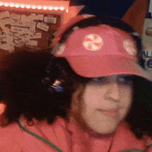 a woman wearing headphones and a pink hat with a swirl on it