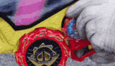 a person is holding a toy car with a red wheel and a blue bottle in their hand .