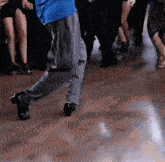 a man in a blue shirt and grey pants is dancing