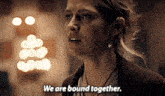 a woman says " we are bound together " in front of a blurry background