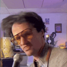 a man wearing sunglasses is singing into a microphone ..