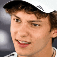 a close up of a young man wearing a white hat