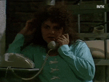 a woman is talking on a telephone with a screen that says " nrk " on it