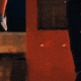 a person is holding another person 's hand in a blurry photo while standing in front of a red wall .