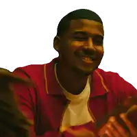 a man wearing a red jacket is smiling and clapping his hands