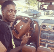 a young man sitting in a bentley car giving a peace sign