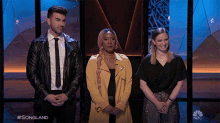 a group of people standing in front of a nbc sign