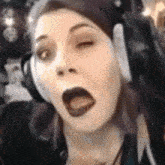 a woman wearing headphones is making a funny face
