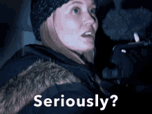 a woman holding a microphone with the words seriously written below her
