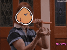 a woman holding a carrot with a cartoon face on her face and the words $booty below her