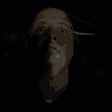 a man with a white mask on his face looks at the camera