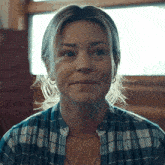 a woman wearing a plaid shirt and a chain around her neck