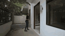 a woman is standing in front of an empty house with the words made in animatica on the bottom
