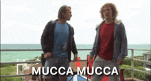 two men are standing on a balcony with the words mucca mucca written on the bottom