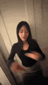 a woman is standing in front of a mirror and looking at herself .
