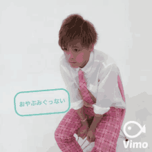 a man wearing pink plaid pants and a white shirt with a vimeo logo on the bottom right