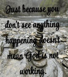a stack of rocks on a rocky shoreline with a quote about god