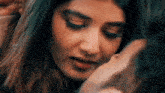 a close up of a woman 's face with a man 's face in the background .