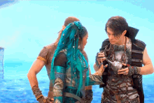a woman with blue hair is standing next to a man