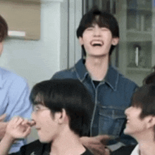 a group of young men are laughing and talking to each other .