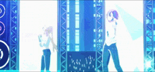 a couple of people standing in front of a stage with a blue background