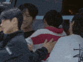 a person wearing a stussy shirt is being hugged