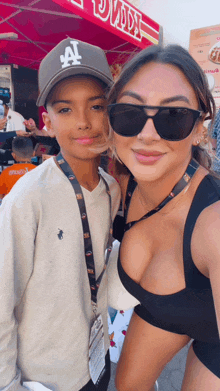 a boy wearing a la hat poses for a photo with a woman