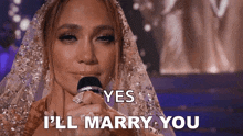 a woman in a wedding dress is singing into a microphone and says yes i 'll marry you