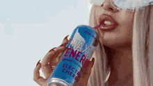 a woman is drinking from a can of max energy