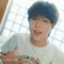 a close up of a person wearing a white t-shirt that says okay