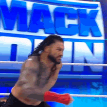 a wrestler in a boxing ring with the word mack down behind him
