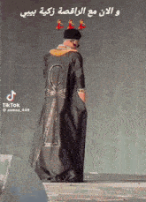 a man wearing a black coat with an ankh on it