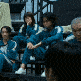 a group of people are sitting on a bench with their hands on their faces