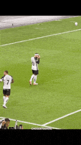a group of soccer players are on a field and one has the number 26 on his shirt