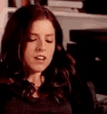 a woman is sitting in a chair with her eyes closed and her mouth open .